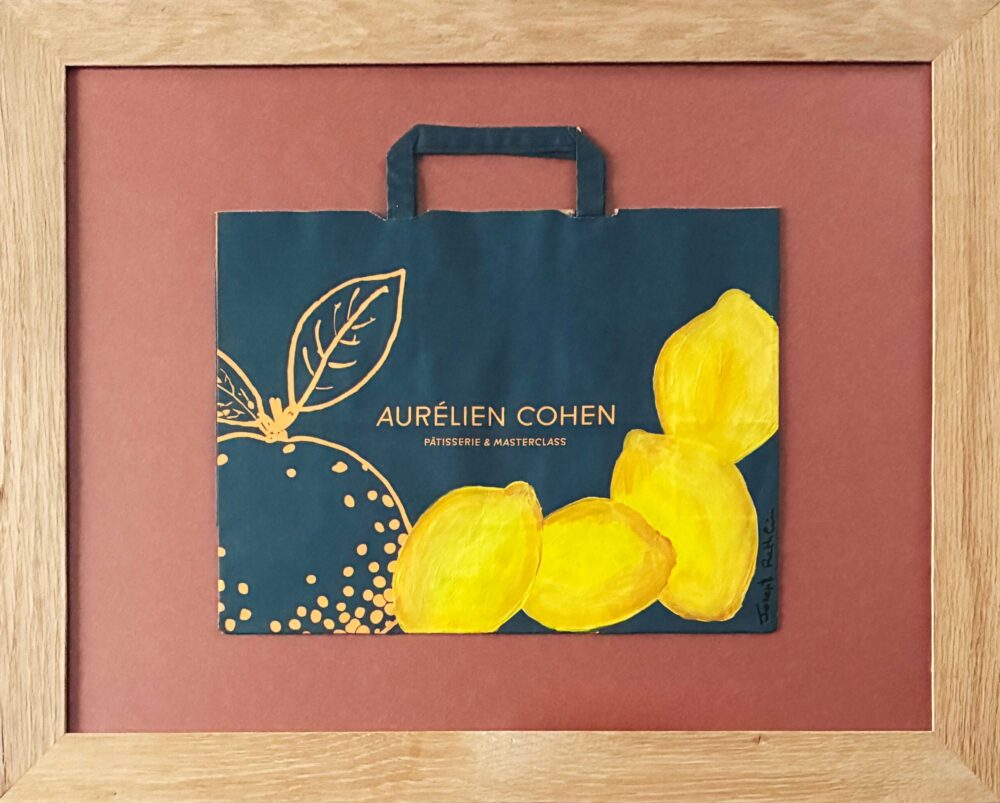 Un sac de courses en papier kraft bleu et quelques citrons.
